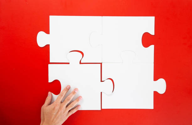 istock Concept of business,hand solving a puzzle piece on red background. 1294002228