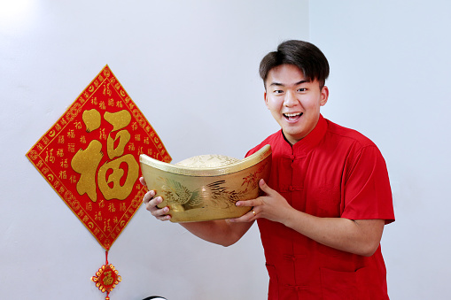 An Asian young man is feeling cheerful for Chinese New Year celebration.
