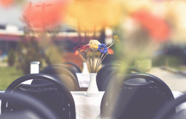vase with flowers on table of outdoor restaurant