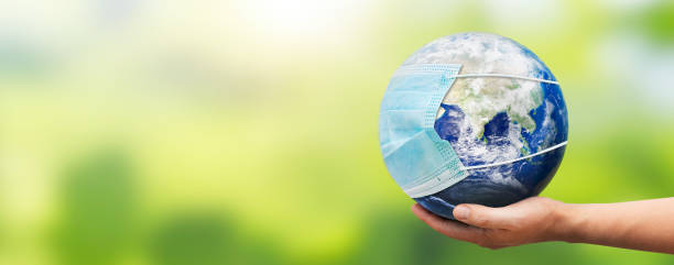 istock Hand holding Earth globe with face mask 1294015589