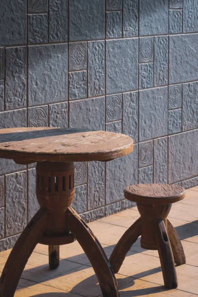 istock the old vintage wooden round table set with gray cobblestone tile wall in perspective side view 1294021182