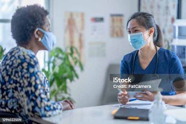 Asian Female Doctor Meeting Patient Stock Photo - Download Image Now - Patient, Doctor, Protective Face Mask