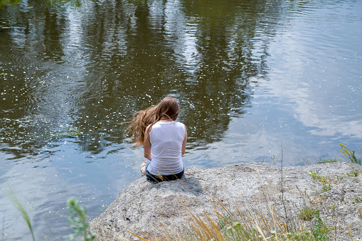 Chelyabinsk Russia June 24 2012 a lonely girl sits on a rock by the river