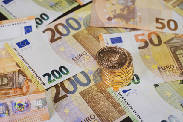 金貨の積み重ねは、広がるユーロ紙幣の上にある - pile of newspapers audio ストックフォトと画像