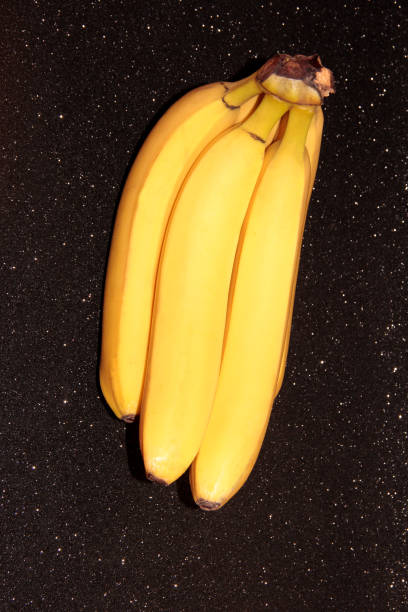 istock Bananas on a black background with bokeh and glitter. 1294025601