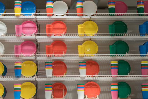 Colorful group of plastic plates on the shelf.