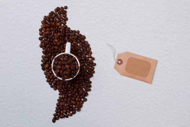 istock Cup of coffee beans on a pile and blank tag. 1294029166
