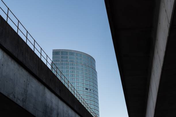 Spans to two concrete bridges that cross the River Lagan, supporting a railway track and motorway, Belfast, Northern Ireland.  In the distance is a mixed use high-rise tower, the Obel, designed by Broadway Malyan and Chris Marshall, and completed in 2011.