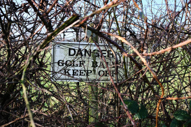 istock Danger sign in a hedge for golf balls. 1294034955