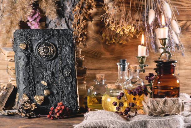 Witchcraft. Spell book, magic potion on the witch doctor desk table background. potion bottle retro revival old fashioned stock pictures, royalty-free photos & images