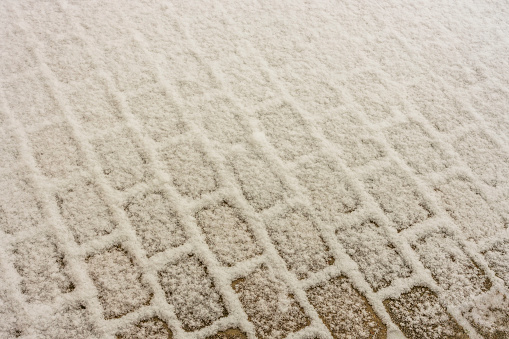 View of beautiful snow covered paving slabs. Winter pattern texture concept.