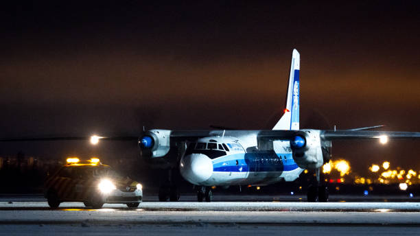 Kostroma Air Enterprise Antonov An-26 Kostroma Air Enterprise Antonov An-26B-100, RA-26133, taxiing from the stand with Follow-Me car. Pulkovo International Airport, Saint-Petersburg, Russia. 18 December 2020 antonov an 26 stock pictures, royalty-free photos & images