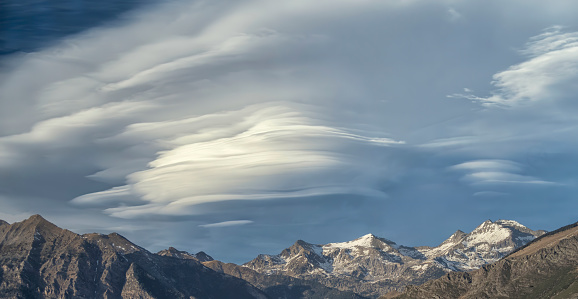 Lenticular clouds over snowy mountains in the ski resort of Boi Taull, Pyrenees Lleida, Spain