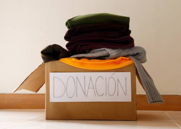 istock Donation written in Spanish (Donación) on a cardboard box. Clothes donation concept. 1294039396