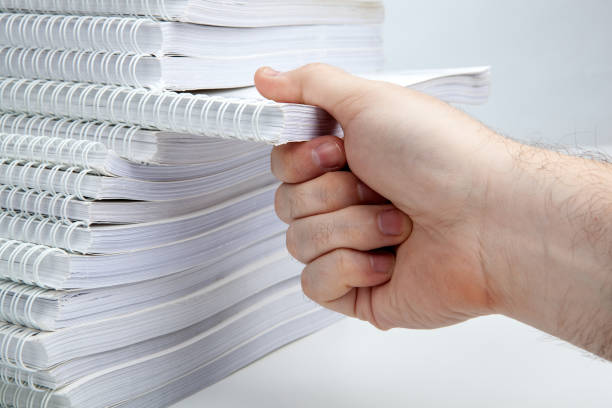 istock man's hand takes one notebook from a stack of notebooks close up 1294043336