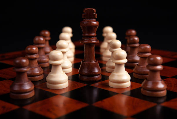 istock chess pawns and king on a board on a black background close up 1294043354