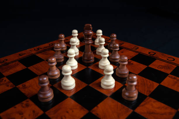 istock chess pawns and king on a board on a black background close up 1294043363