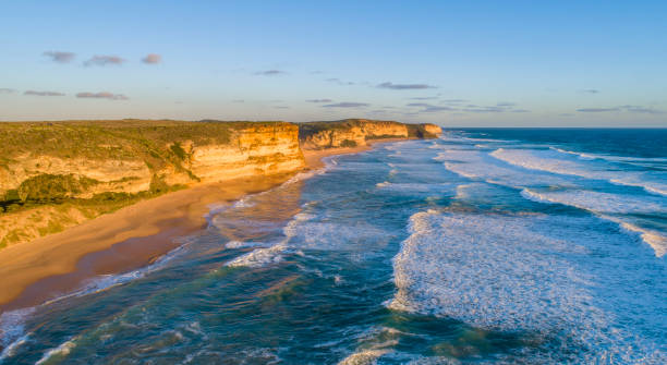 istock Sun shining on sea cliffs, blue water surface with waves, water wave texture 1294045155