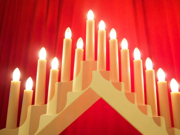 istock Schwibbogen arch luminaire in the form of a triangular candlestick. Red background. Evening, romantic, festive, religious or mystical atmosphere. Burning light bulbs or candlelight. Double exposure 1294045264