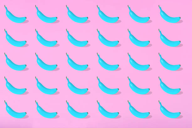 istock Trendy Summer pattern made with fresh banana fruit colored in blue on bright light pink background. 1294045281