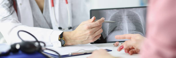 istock Doctor shows the patient an x-ray of lungs 1294046880