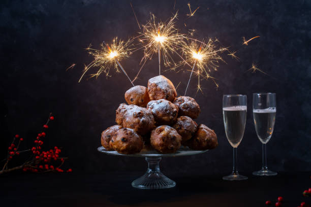 poziome ujęcie stosu oliebollen (tłumaczenie: holenderskie firitters ciasta) z trzech sparklers i szampana na czarnym tle - meal traditional culture heap food and drink zdjęcia i obrazy z banku zdjęć