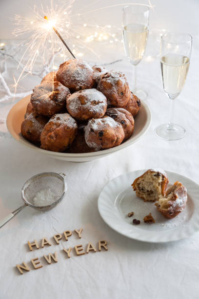 szczęśliwego nowego roku napisane małymi literami i miskę tradycyjnych oliebollen (holenderskie placki ciasta) z sparklers i szampana - meal traditional culture heap food and drink zdjęcia i obrazy z banku zdjęć