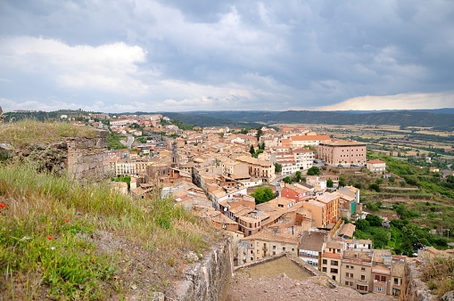 View from Cardona Castle to the town. The roofs of the old town houses. The valley is surrounded by green mountains. Catalonia, Spain.