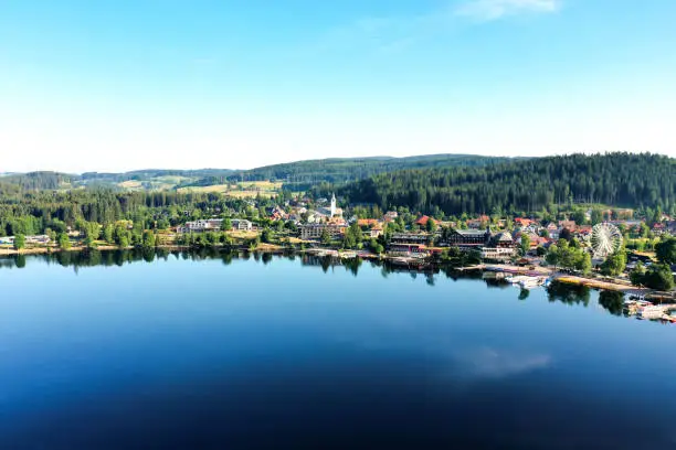 Small town of Lake Titisee near the Black Forest of Germany in summer; blue and calm lake, green hills