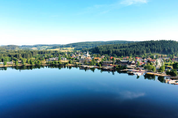 small town of titisee near the black forest of germany; calm lake, green hills - black forest forest sky blue imagens e fotografias de stock