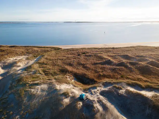 Aerial view of a campsite on sand dunes near an anchored sailboat at Cape Lookout, North Carolina.