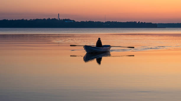 istock A man rowing a boat on an orange lake at sunset 1294053359