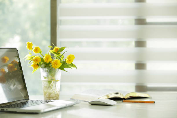 istock Yellow bouquet and computer on home work desk, COVID-19 pandemic, teleworking 1294057634