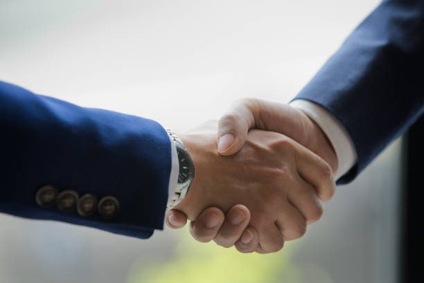 istock Two men in suits shaking hands. Celebrating Cooperation. Agreement reached. 1294057675