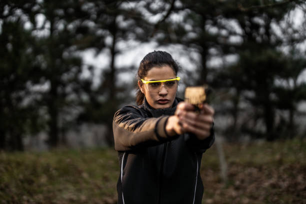 istock Young woman aiming and practising shooting from pistol at shooting range 1294057835