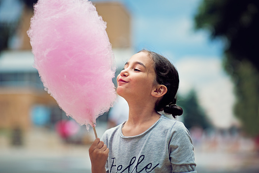 5 years little girl eating a cotton candy in the city, quebec, canada