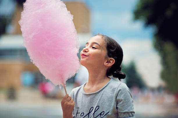 Portrait of little girl eating cotton candy stock photo