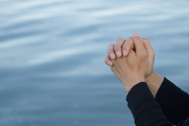 istock Praying for patients with coronavirus, hands clasping on blue background 1294060772
