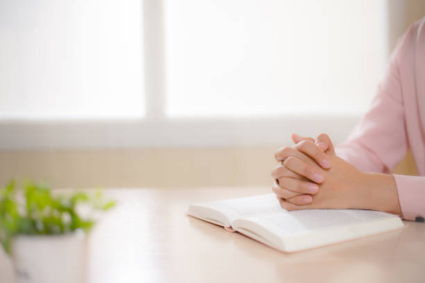 istock Young woman's hands and an open Bible, religion, prayer, coronavirus 1294060774