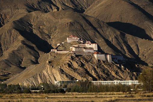 View of Gyantse Dzong, also known Gyangze Castle built on a huge spur of grey brown rock in Tibet, China