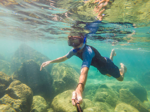 istock young men snorkeling exploring underwater coral reef landscape background in the deep blue ocean with colorful fish and marine life 1294070617
