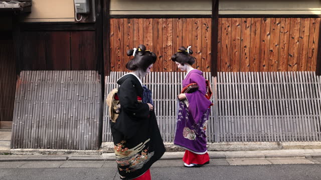 Two Geisha women walking together on street in Gion, Kyoto