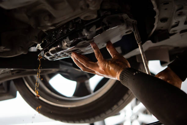 Car mechanic drain automatic transmission fluid Car mechanic drain the old automatic transmission fluid (ATF) or gear oil at car garage for changing the oil in a gear box of car engine liquid stock pictures, royalty-free photos & images