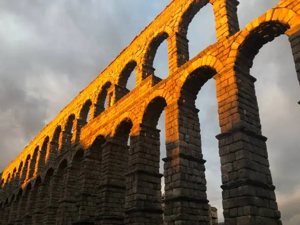 Aqueduct of Segovia with sunset light passing through