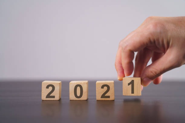istock Text 2021 on wooden cube isolated over background. 1294087830