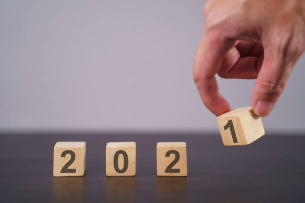 istock Text 2021 on wooden cube isolated over background. 1294087834