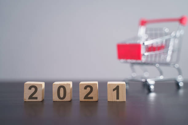 istock Text 2021 on wooden cube with shopping cart. 1294087838