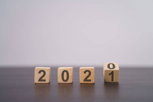 istock Text 2021 on wooden cube isolated over background. 1294087853