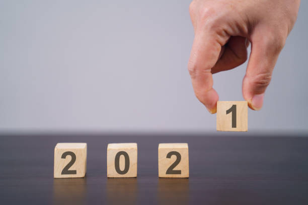 istock Text 2021 on wooden cube isolated over background. 1294087863