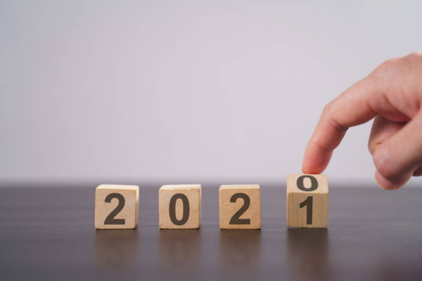 istock Text 2021 on wooden cube isolated over background. 1294087867
